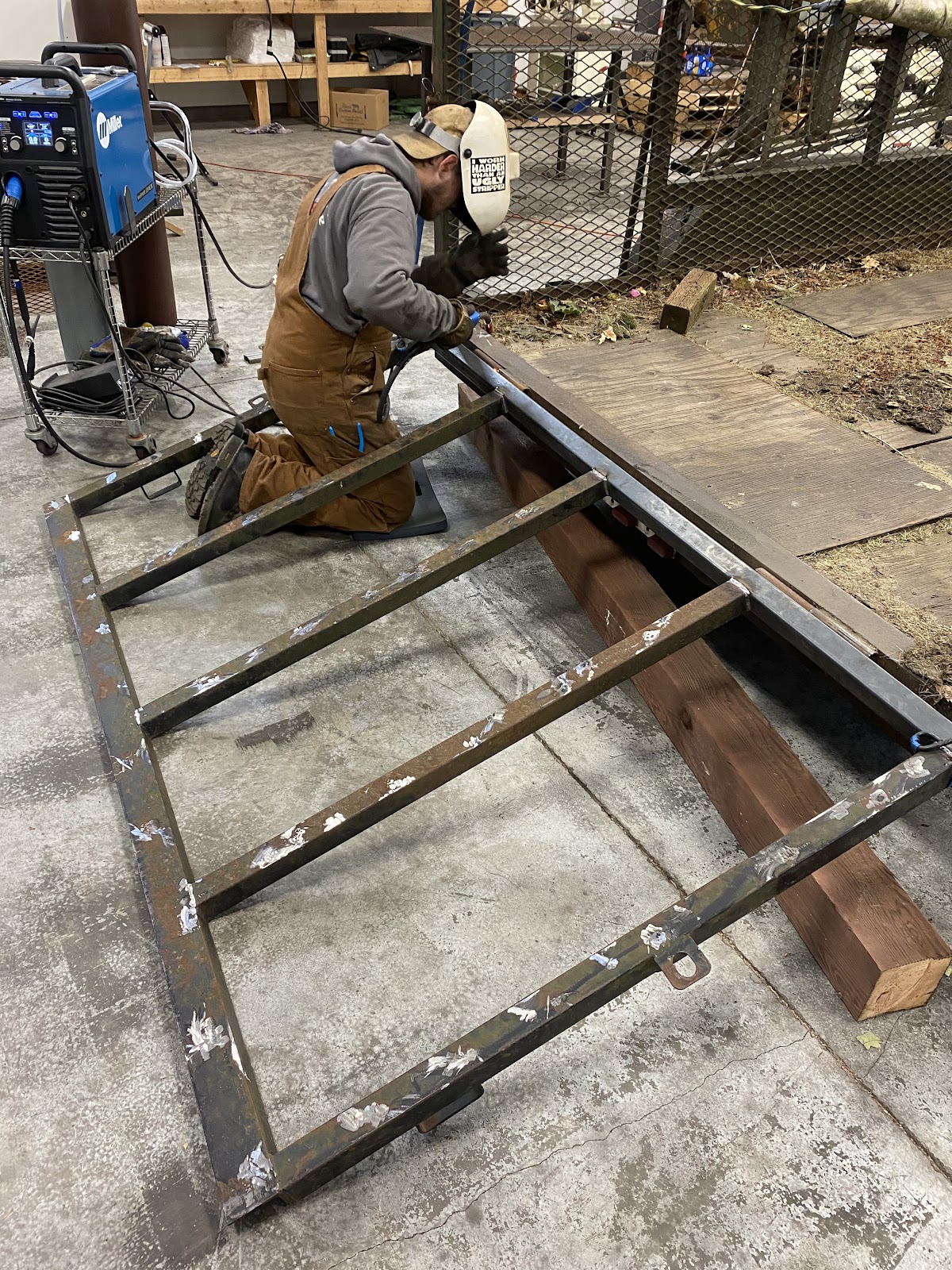 Welder fabricating a large steel gate frame on site