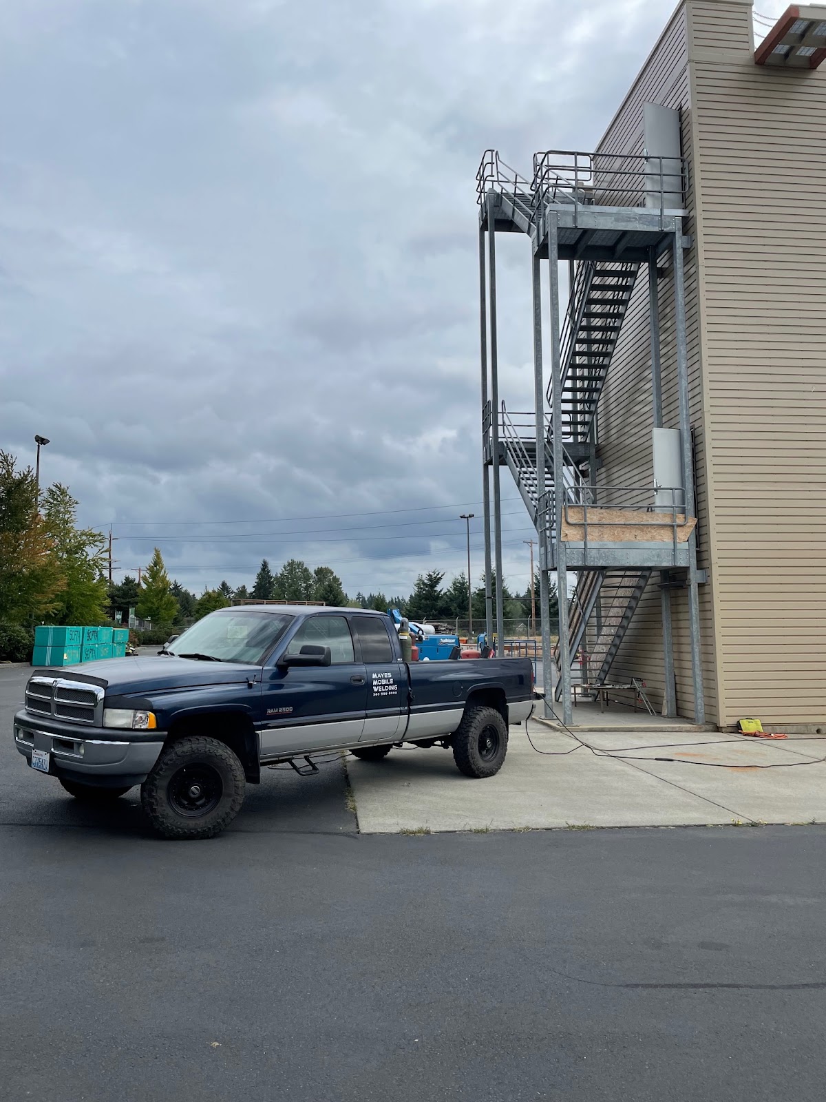 The branded Mayes service truck beside a fabricated commercial steel staircase
